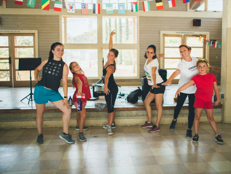 group of girls dancing and posing in a dance studio.