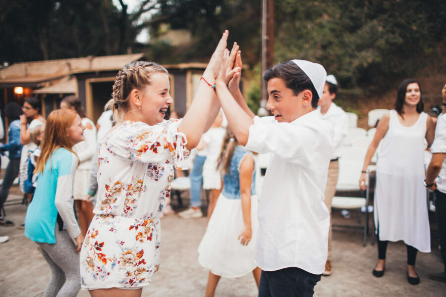 two kids giving each other a double high five.