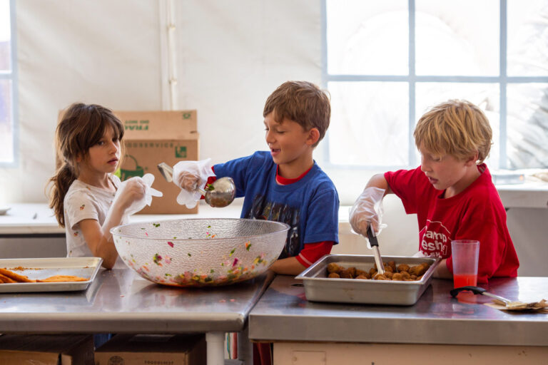 kids serving food in a kitchen.