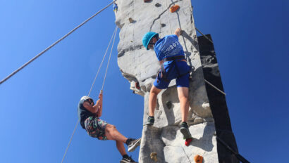 kids climbing up a rock wall.